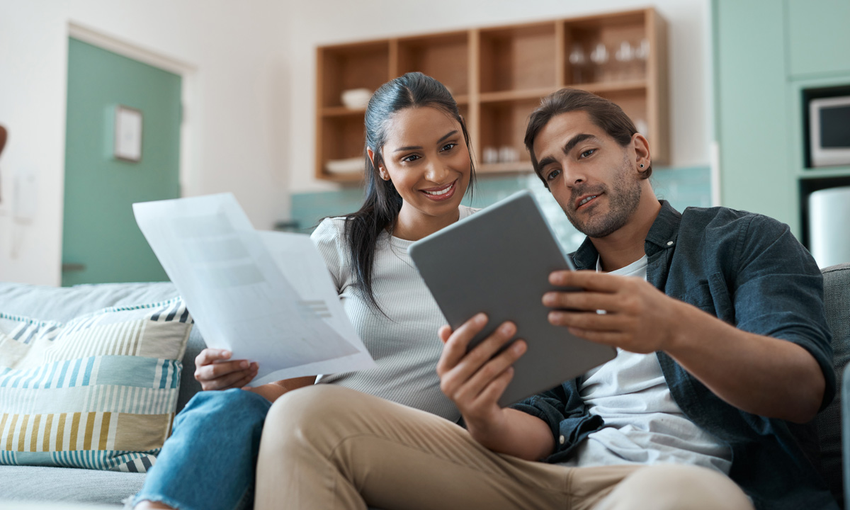 Hispanic couple paying bills on ipad